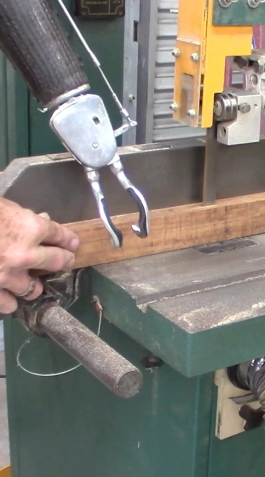 Amputee uses prothetic hook with a saw.