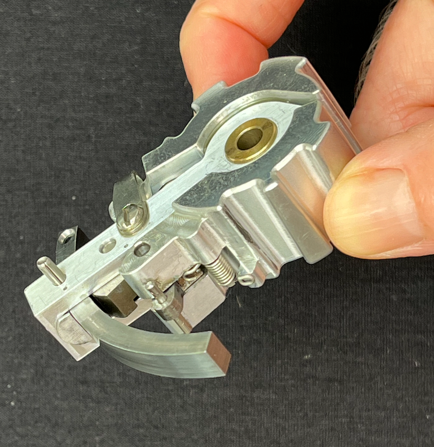 Marins Inc. patented locking cartridge seen from the side, held with fingers, with a black background.